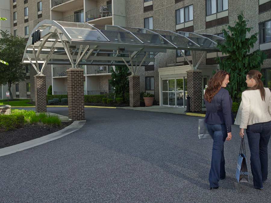 two women walking towards the front door of luxury Whitney Apartments in Claymont DE