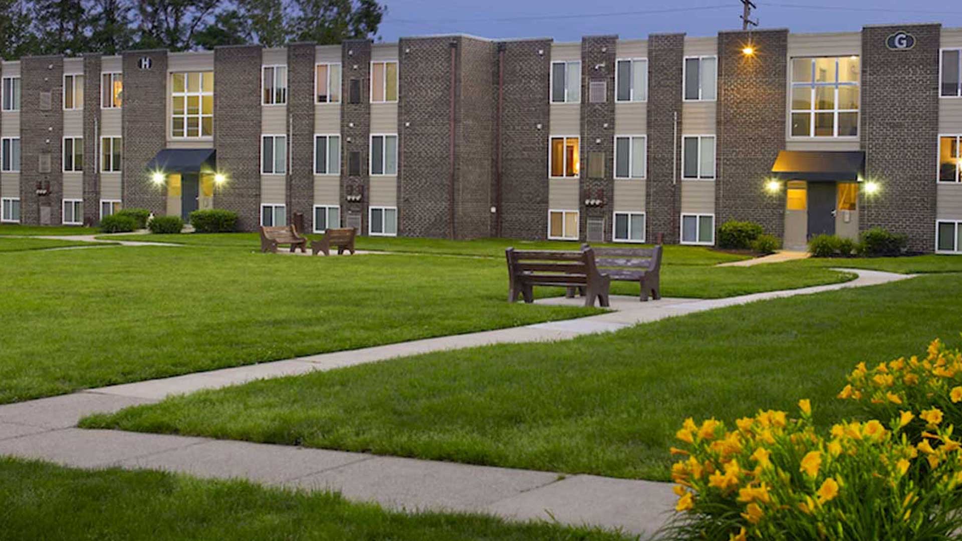 Lion's Gate Apartments building exterior with benches